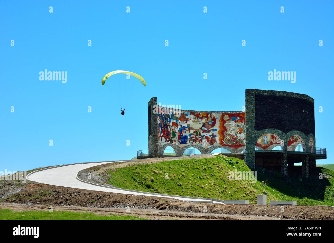 Paragliding über das Denkmal der georgisch-russischen Freundschaft. Jvari Pass. Georgien, Kaukasus Stockfoto