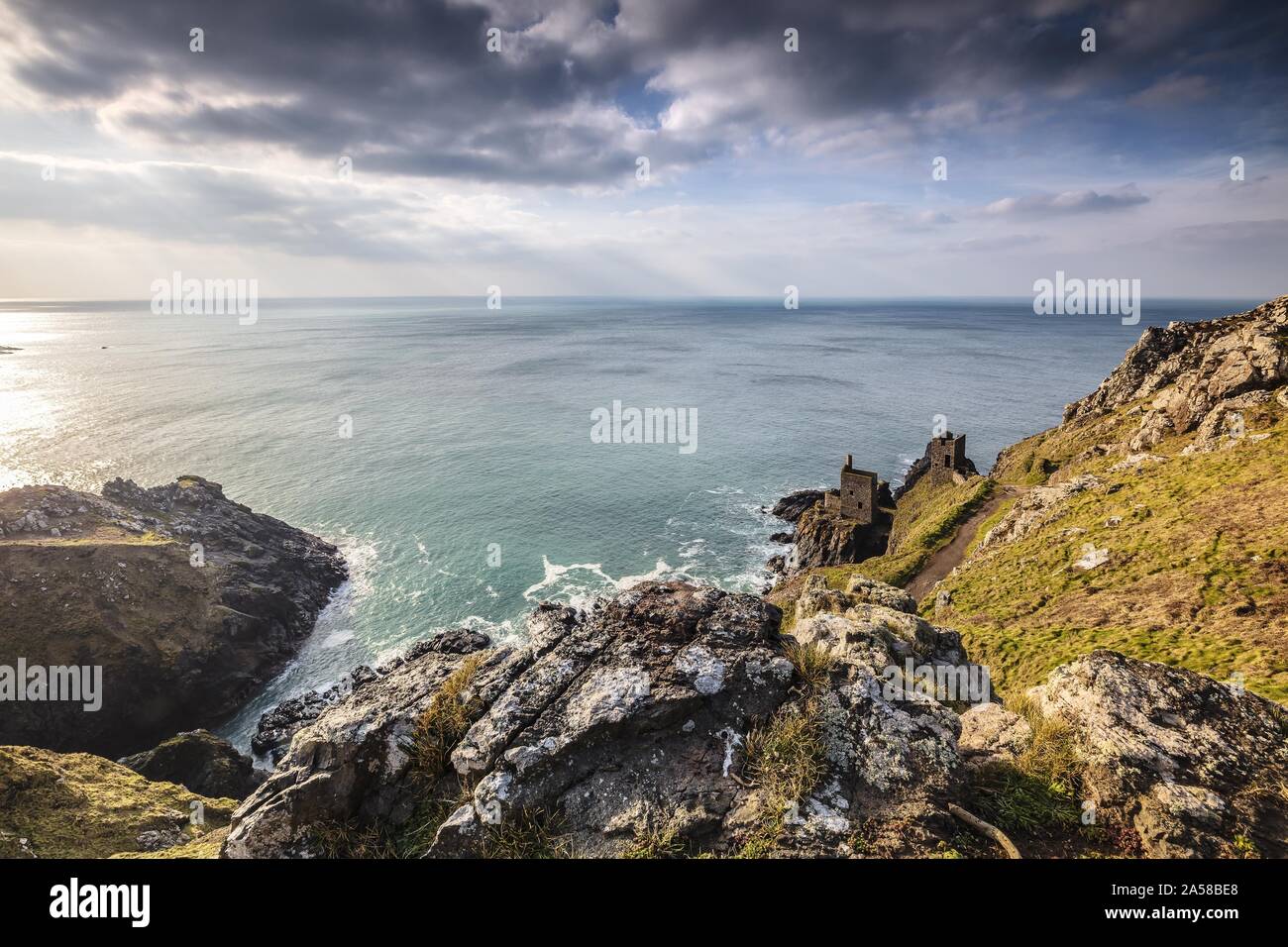 Helle Landschaft eines Ozeans mit einem Berg am Ufer in Mining Ruins, Botallack, Cornwall, Großbritannien Stockfoto