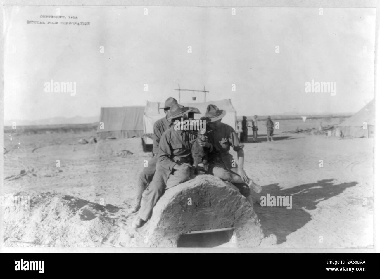 Us-Armee Zelt Camp in Mexiko, 1914: 3 Soldaten sitzen auf Feld Backofen mit Baby Ziege Stockfoto