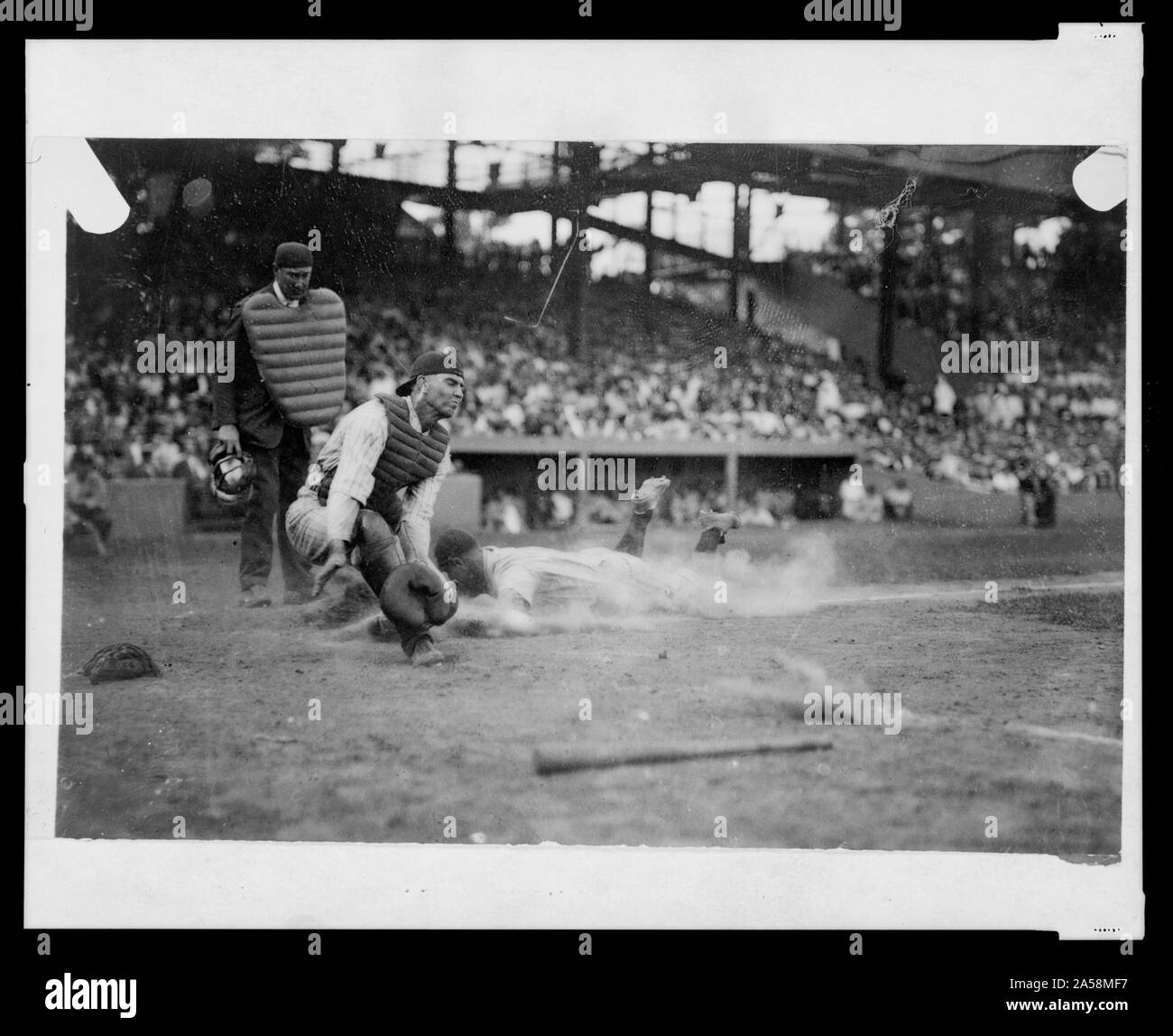 Schiedsrichter Nallan bereit ist, den Anruf zu machen als Washington catcher Hank Severeid ball erwartet, während New York Yankee Lou Gehrig in die Home Plate Folien während baseball spiel Stockfoto