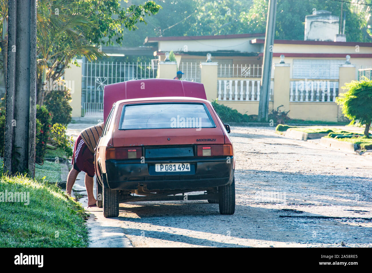 Ein Mann, der an seinem Auto arbeitet; Camaguey, Kuba Stockfoto