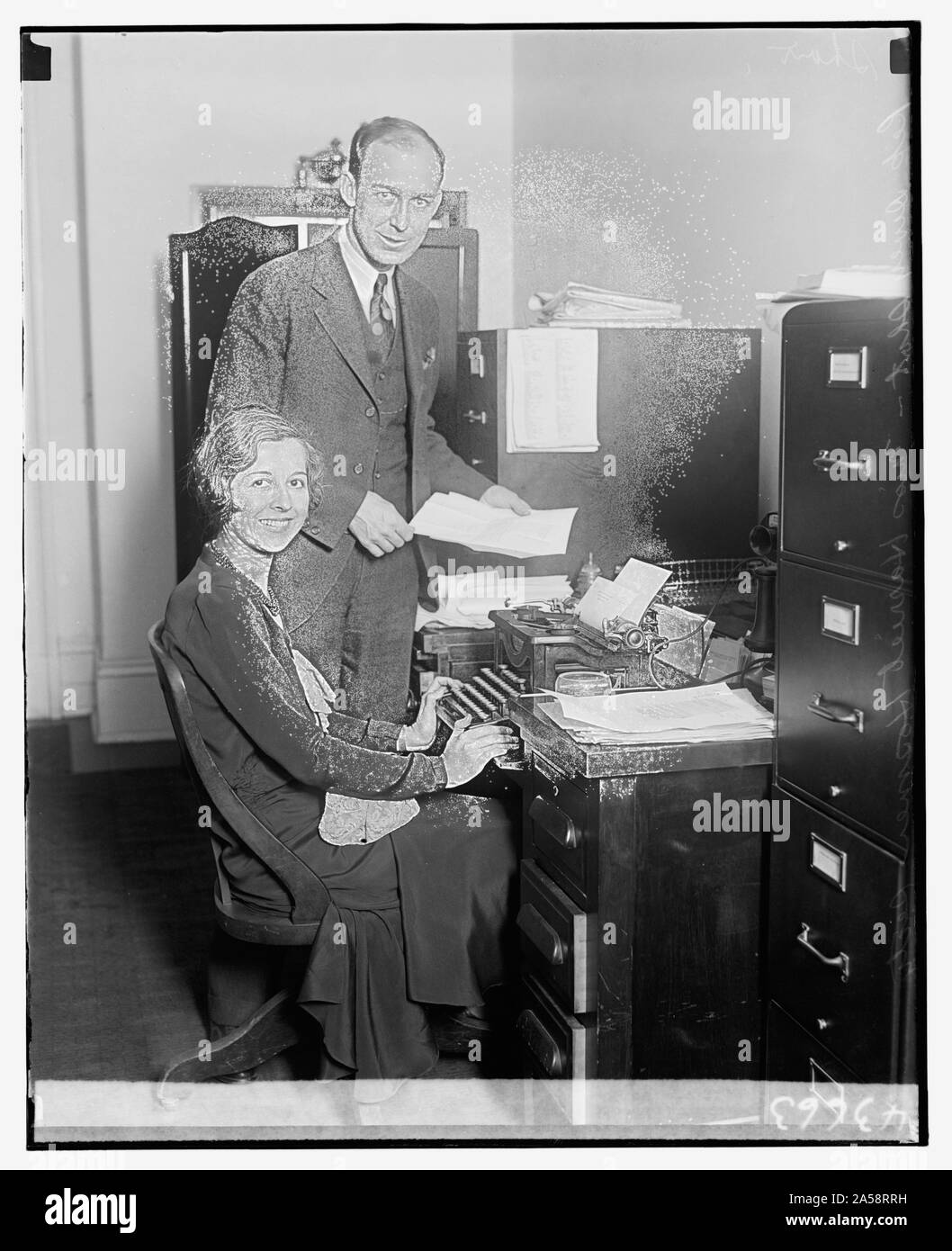 Unbekannter Mann und Frau am Schreibtisch mit Schreibmaschine Stockfoto