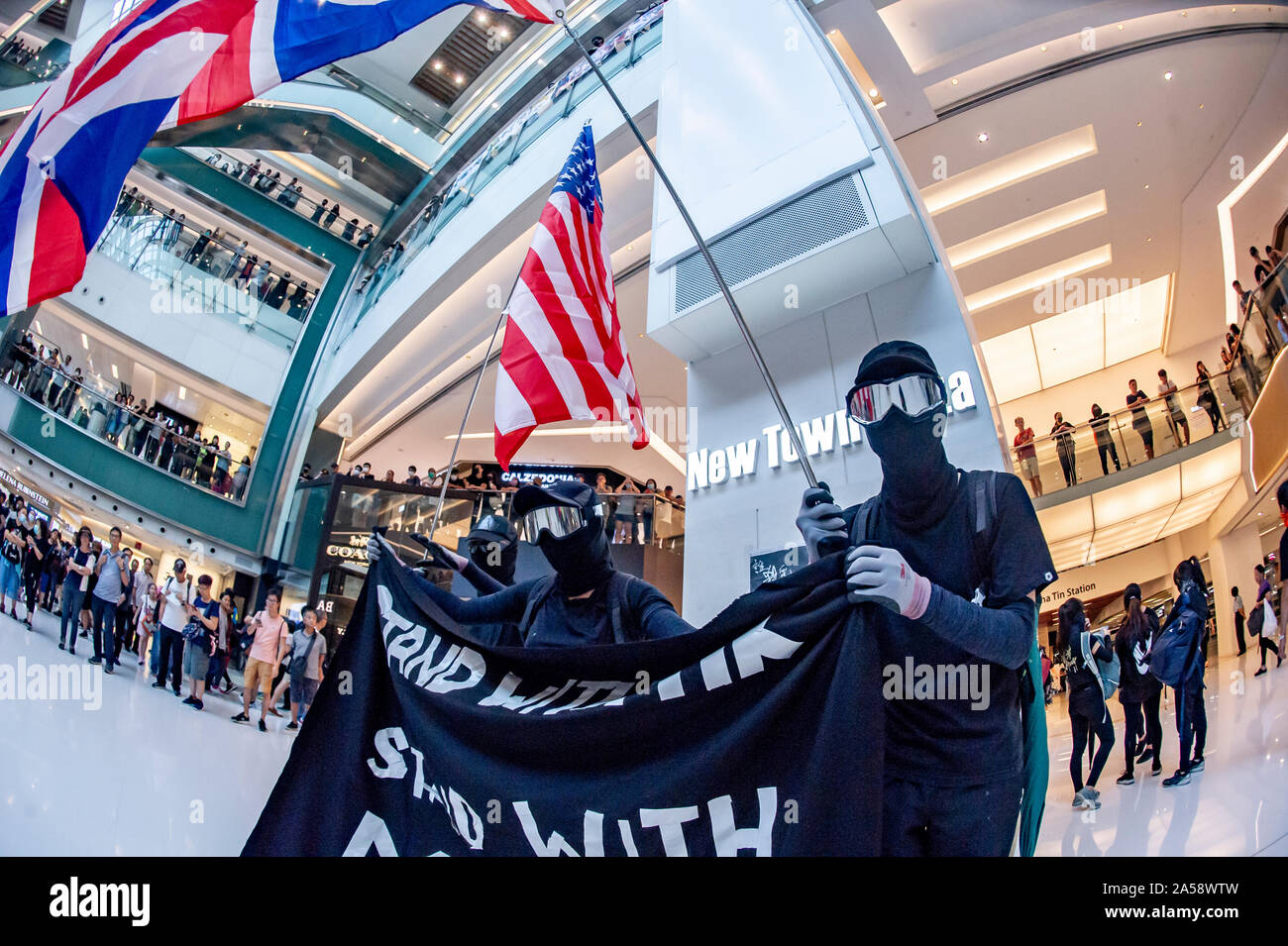 Hong Kong Demonstranten Welle britische und amerikanische Flaggen in Protest in einem Einkaufszentrum in Hongkong vor Gewalt ausbricht Stockfoto