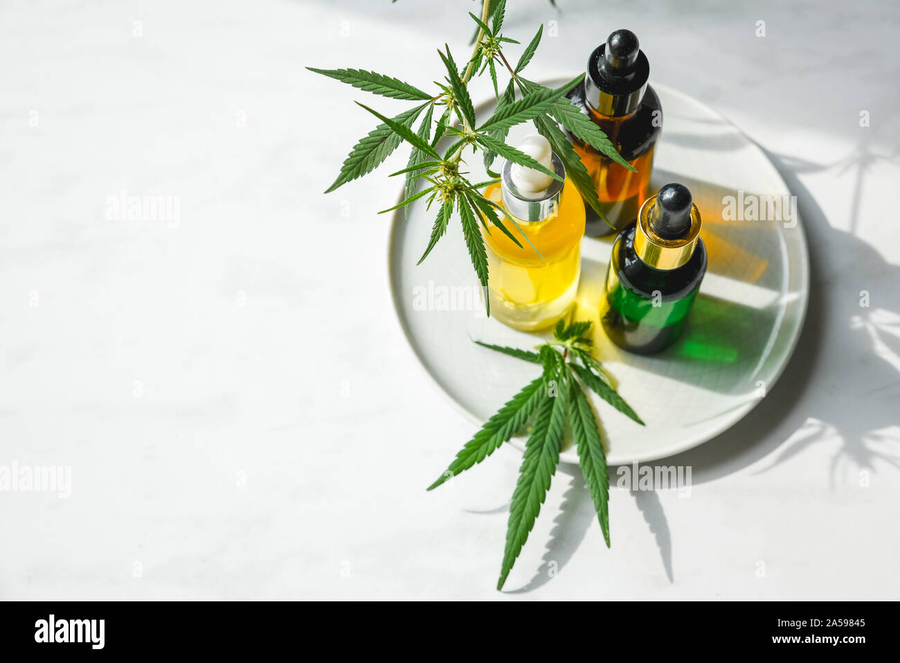 Glas Flasche und Dropper CBD ÖL, THC Tinktur und Cannabis Blatt auf Hintergrund. Labor Herstellung von Kosmetika mit CBD Öl. Stockfoto