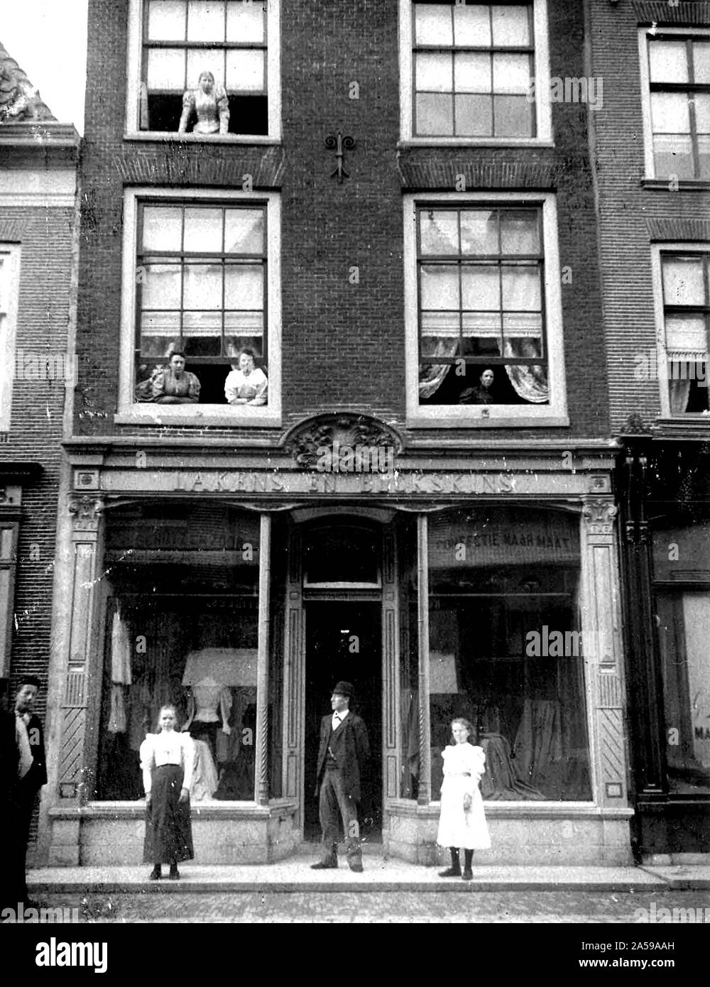 Personen außerhalb eines Gebäudes auf Langestraat in Alkmaar Niederlande stehend Ca. 1900 (lange Straße). Stockfoto
