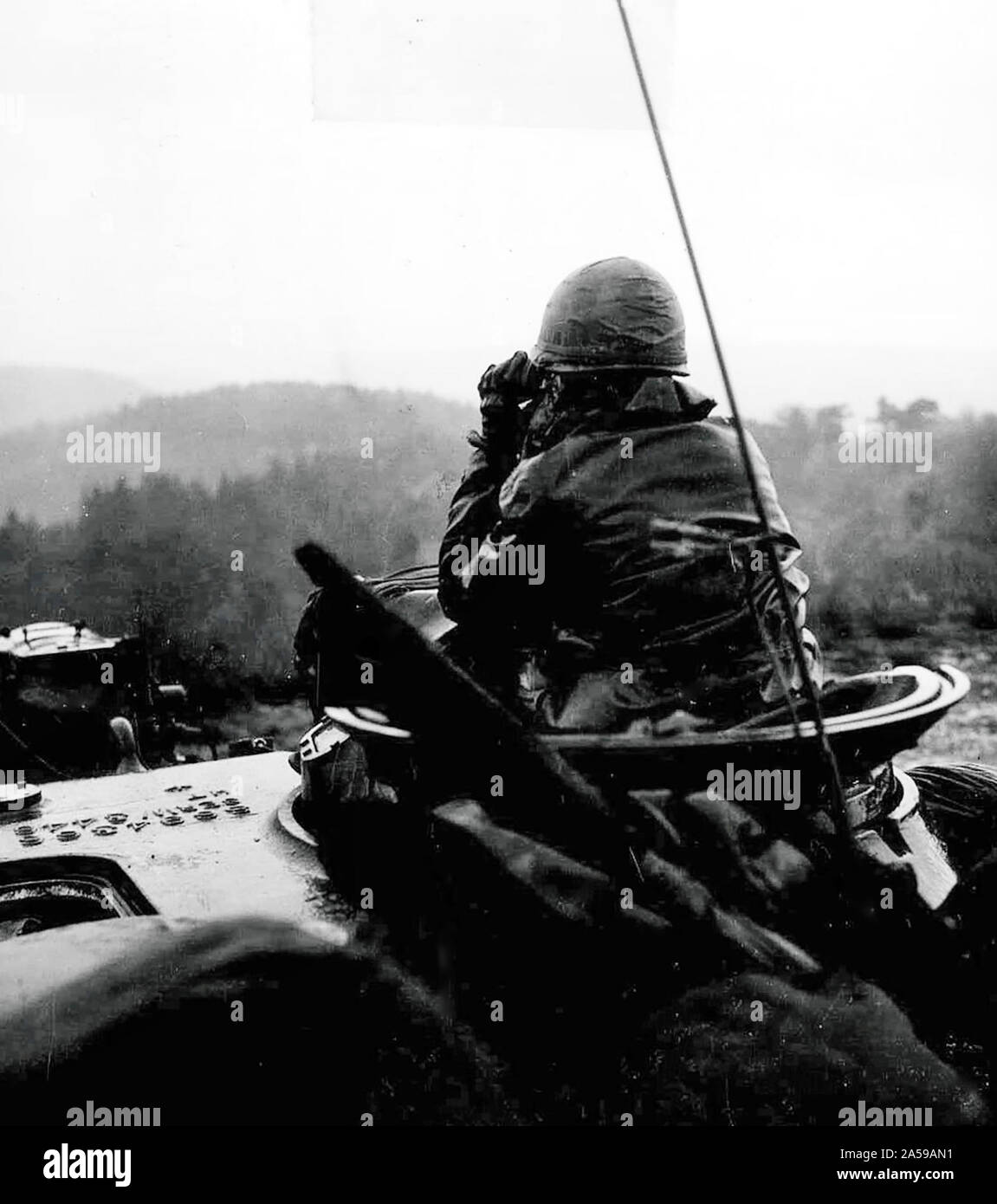 Ein Soldat mit Charlie Company, 1st Battalion, 67th Panzer Regiment, 2. Panzerdivision, der Suche nach einem Ziel nach unten reange während Tank brennen bei Baumholder, Deutschland - die Operation "Big Lift." Ca. 11/8/1963 Stockfoto