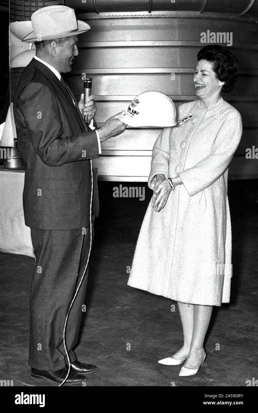 Marshall Space Flight Center Direktor Dr. Wernher von Braun präsentiert Lady Bird Johnson mit einem eingeschriebenen Hard hat während der ersten Dame des 24. März 1964 besuchen. Stockfoto