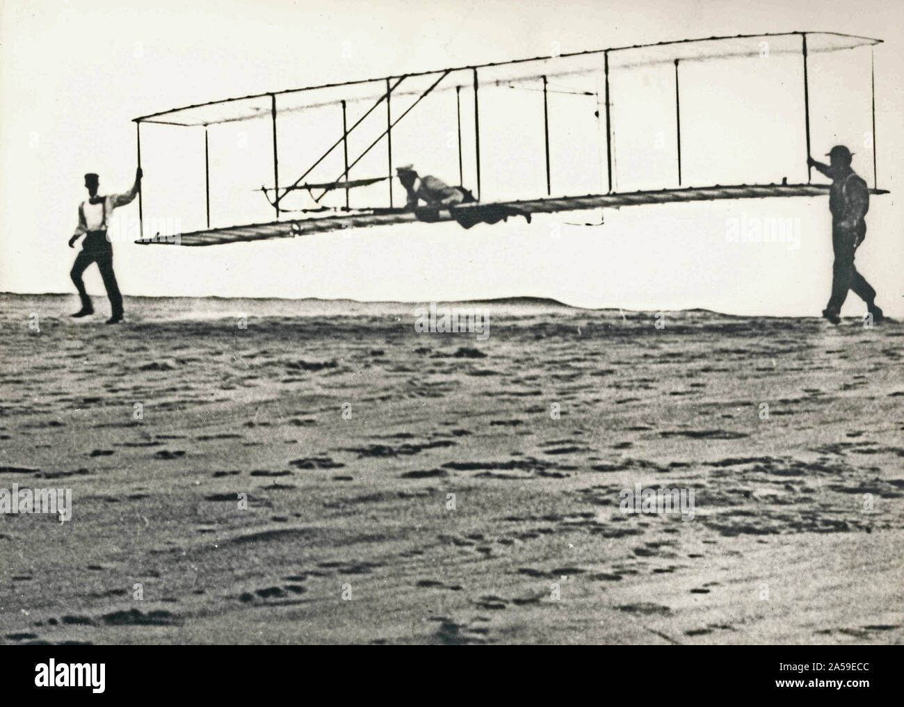 Historisches Foto von Dritten test Segelflugzeug die Brüder Wright' gestartet wird bei Devil Hills, North Carolina, am 10. Oktober 1902 zu töten. Wilbur Wright ist an den Kontrollen, Orville Wright ist auf der linken Seite, und Dan Tate (ein Anwohner und Freund der Brüder Wright) ist auf der rechten Seite. - Die 1902 test Segelflugzeuge waren äußerst wichtig für die Entwicklung des ersten angetriebenen Flugzeug. Stockfoto