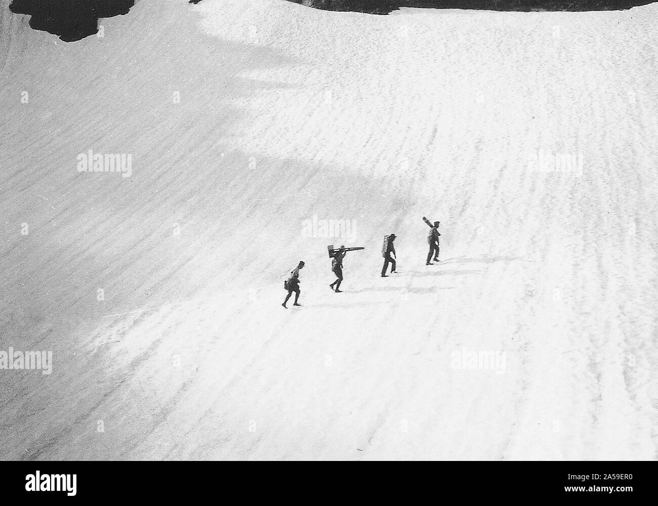 USGS topografische Feld Partei Überqueren einer schneeverwehung an der Spitze der Grand Creek über ihr Lager in der Nähe von Moose Lake, während die Zuordnung des Mt. Bodensee Kartenblatt, in die Olympischen Berge von Washington. Dies wurde am 29. Juli, 1931 Stockfoto