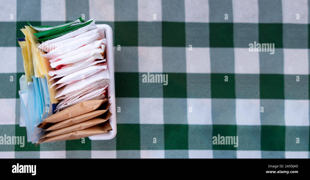 Zucker Pakete auf einem karierten weiß und grün Tischdecke Stockfoto
