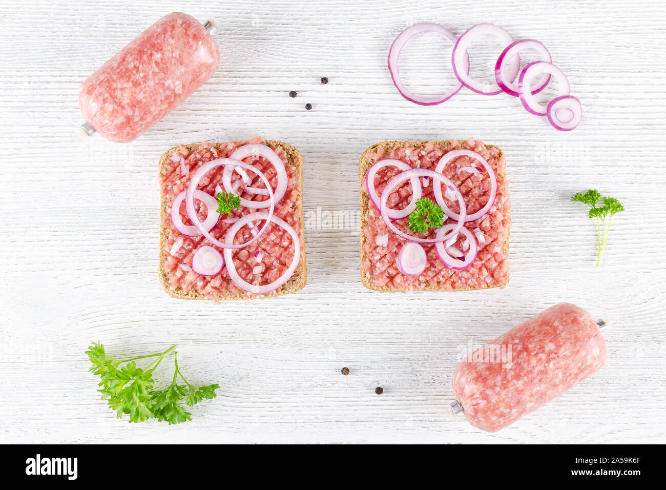 Deutsche essen mett Boden Schweinefleisch, Bun- und rohes Fleisch mit Zwiebeln, Pfeffer und Petersilie, Zutaten, flach Stockfoto