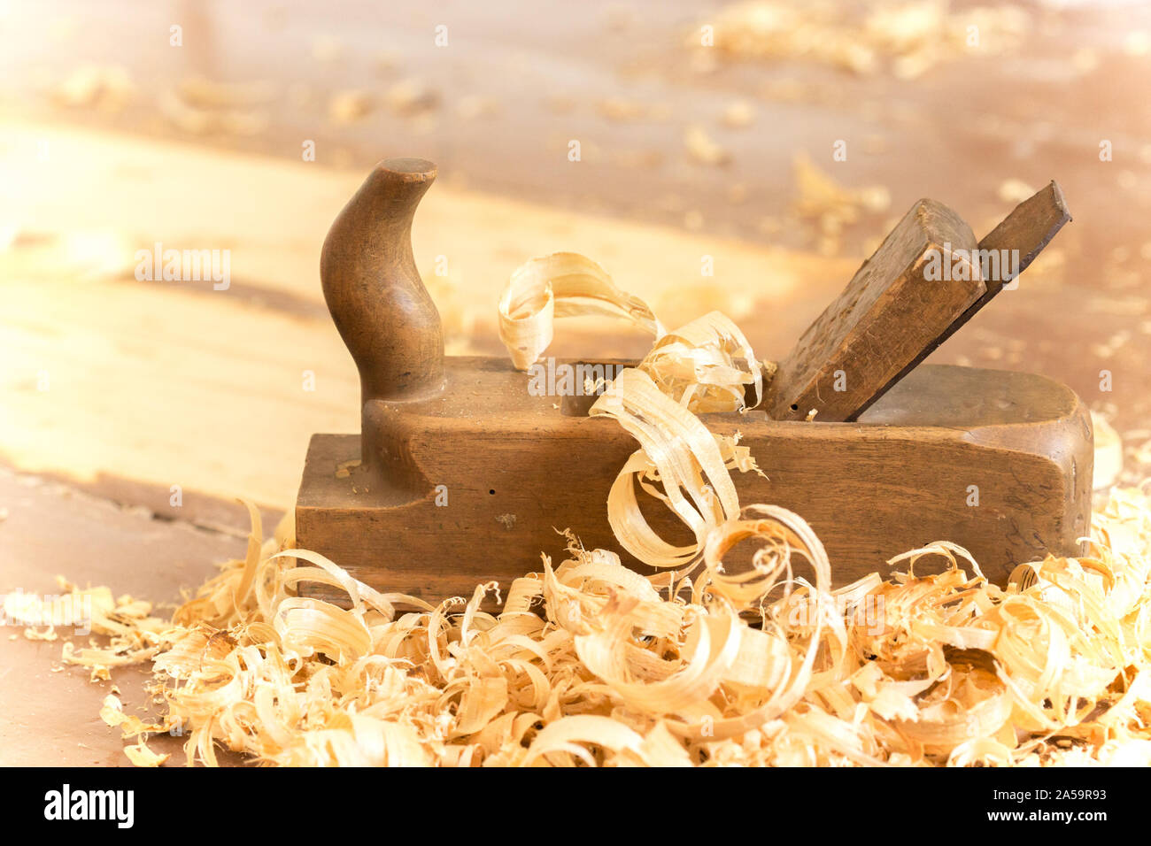 Alte hölzerne Hand Ebene für die Holzbearbeitung mit Holzwolle. Stockfoto
