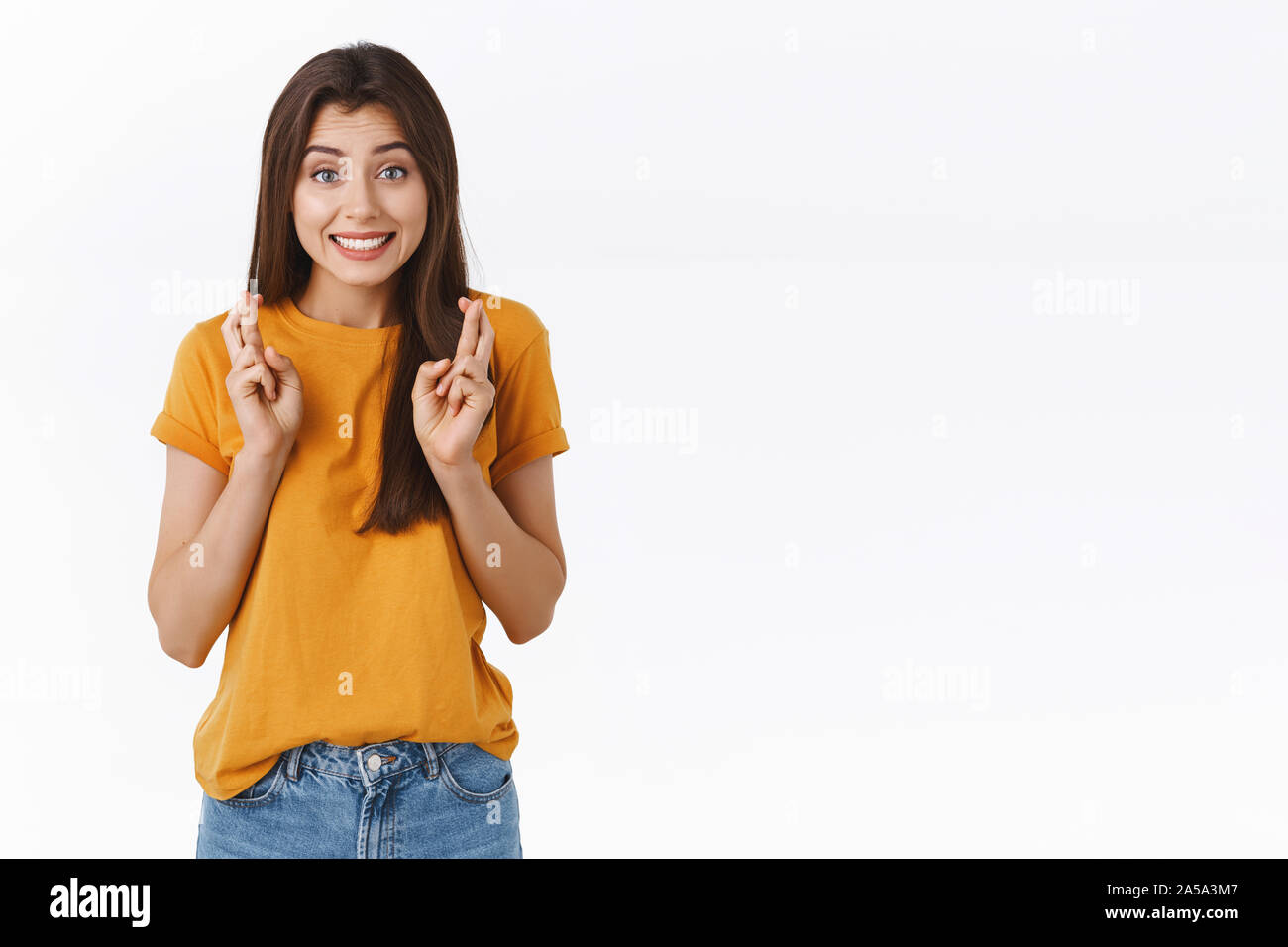 Fröhlich, hoffnungsvoll und optimistisch cute sligtly nervös brunette Mädchen Glauben an sich selbst, wollen, Bestehen der Prüfung, lächelnd anticiapting Ergebnisse, Kreuz Stockfoto