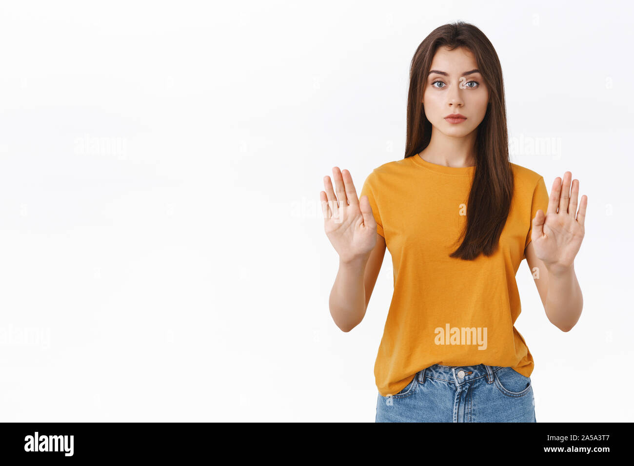 Ernst - schauen zuversichtlich gut aussehende Frau im gelben T-Shirt, heben die Hände im Stop, Tabu oder Verbot Bewegung, schauen sie nur ungern und selbstbewussten Stockfoto