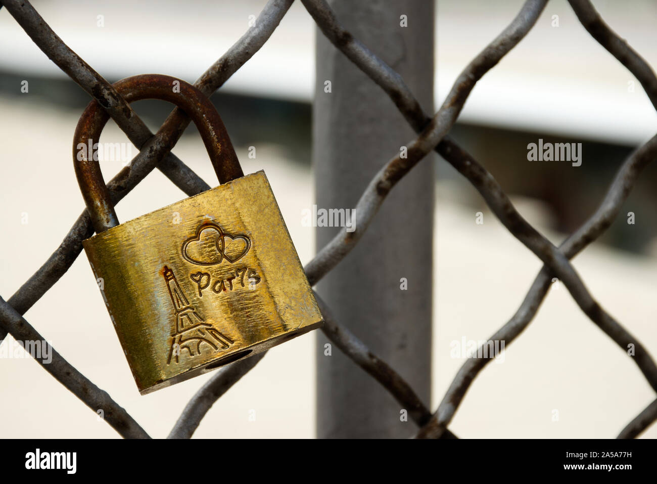 Single Kupfer Liebe-lock, montiert auf der Grauen und rostigen Zaun einer Brücke in Paris, Frankreich. Verwendbar als Hintergrund mit Ihren eigenen Text. Stockfoto