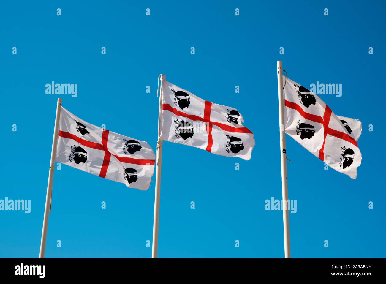 Die Flagge von Sardinien und Korsika, vier Mauren Fahne / Flagge der vier Mauren fliegen in einem klaren, blauen Himmel Stockfoto