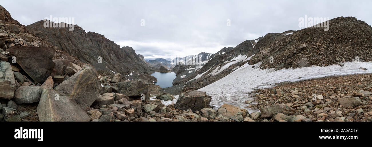 Ein nach Süden Blick auf die alpine Seen aus dem Sattel von alpinen Seen vorbei. Schneefeld und schneebedeckten Gipfel in der Ferne gesehen. Stockfoto