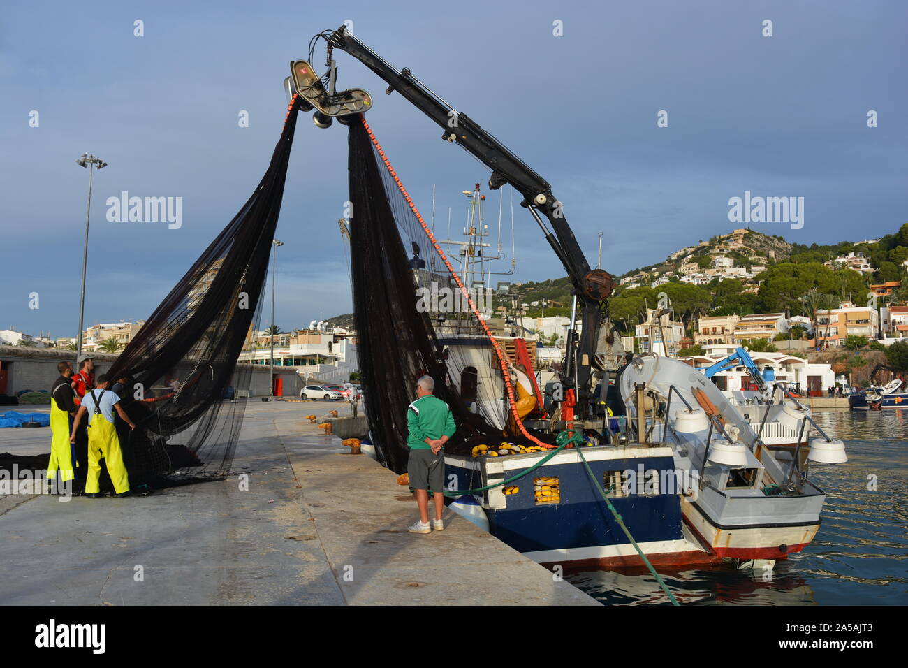 Fischer Reinigung der Trawler fischernetze am Hafen, Javea, Xabia, Provinz Alicante, Spanien, Stockfoto