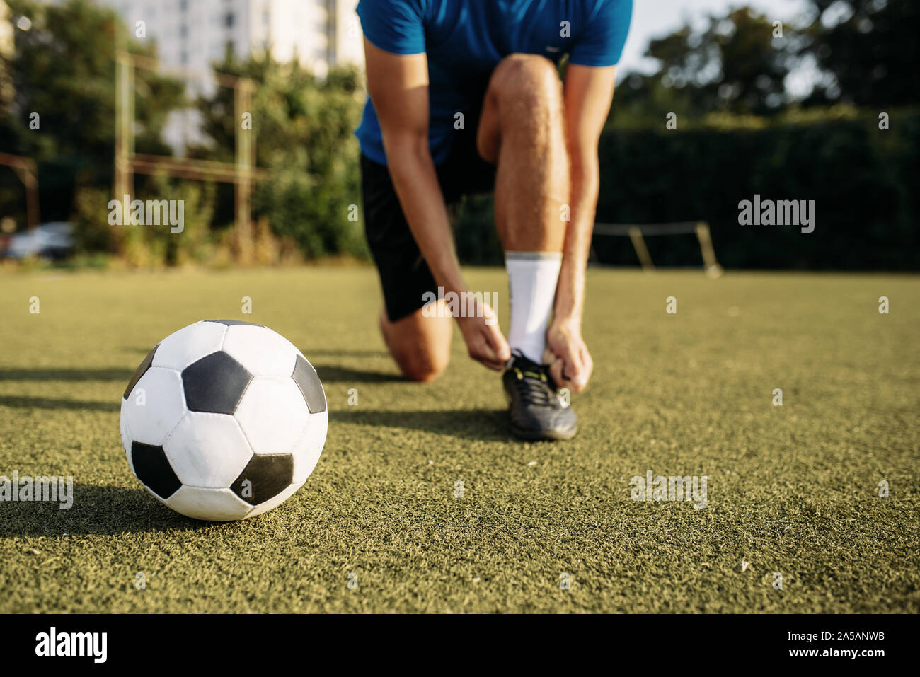 Männliche Fußballspieler Bindungen seine Schnürsenkel für Stiefel Stockfoto