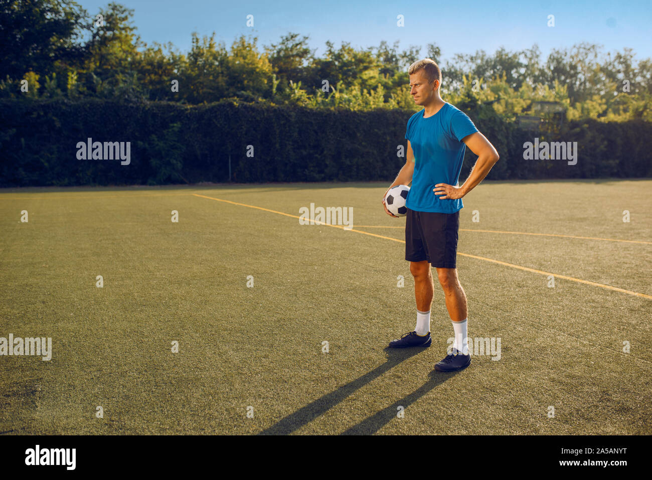 Männliche Fußballspieler mit Ball stehend auf dem Feld Stockfoto