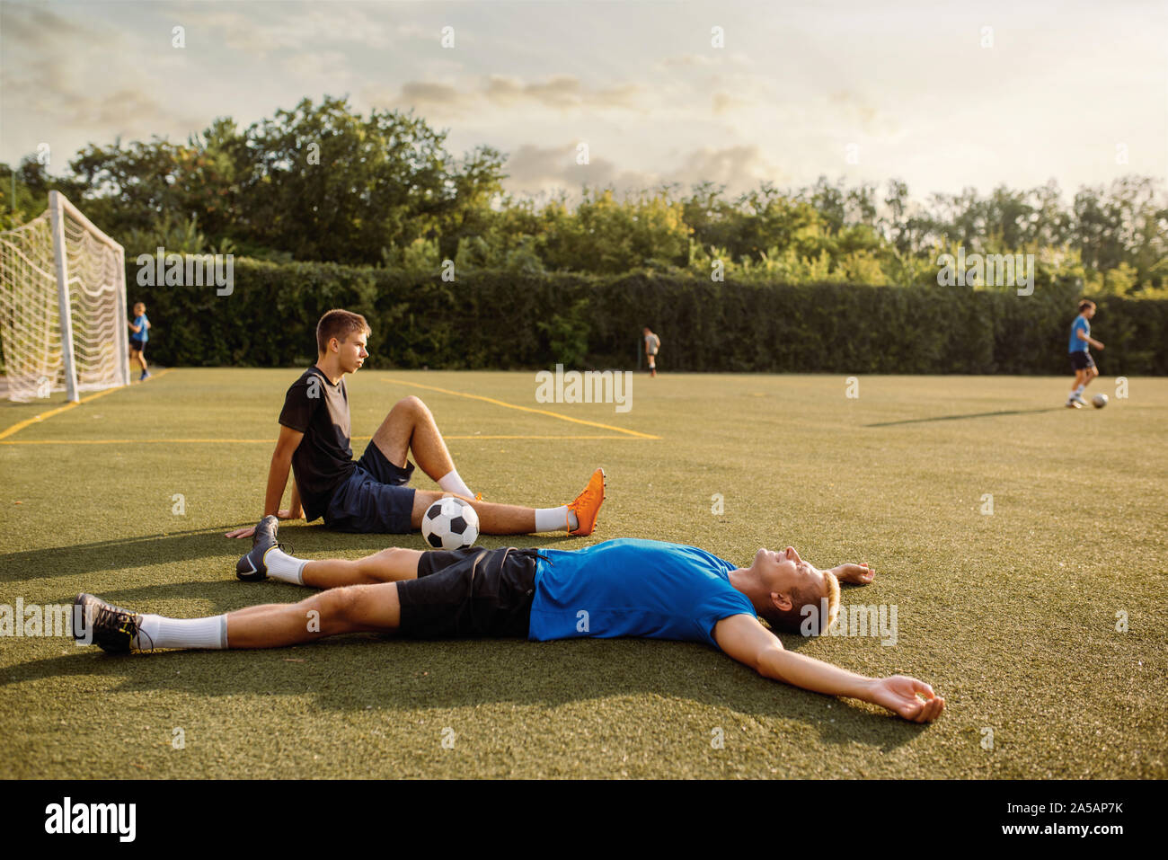 Zwei männliche Fußballspieler ruht auf dem Gras Stockfoto