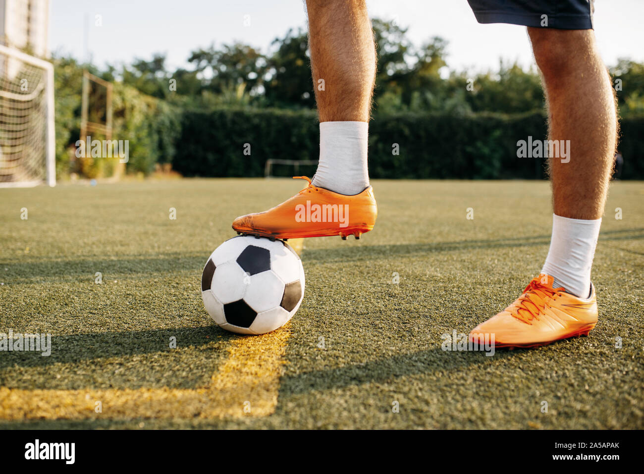 Männliche Fußballspieler Beine mit Kugel Stehend auf Linie Stockfoto