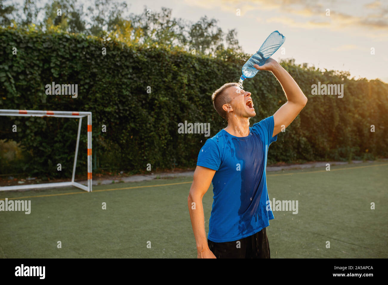 Männliche Fußballspieler übergossen mit Wasser auf dem Kopf Stockfoto