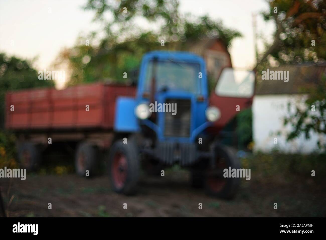 Blaue Traktor mit Anhänger steht auf einem Bauernhof Dorf, Landschaft Stockfoto