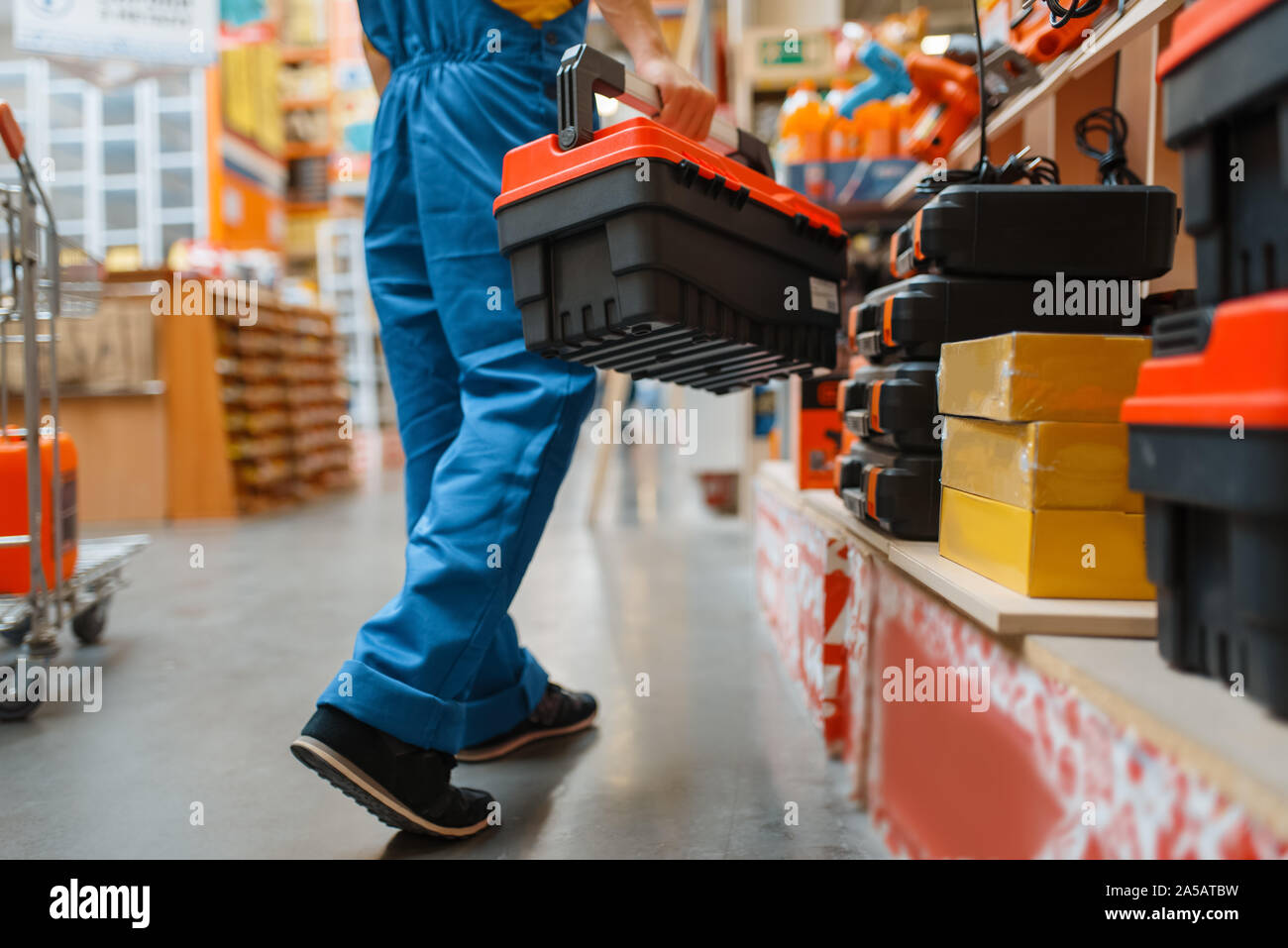 Builder mit Toolbox am Regal, Hardware Store Stockfoto