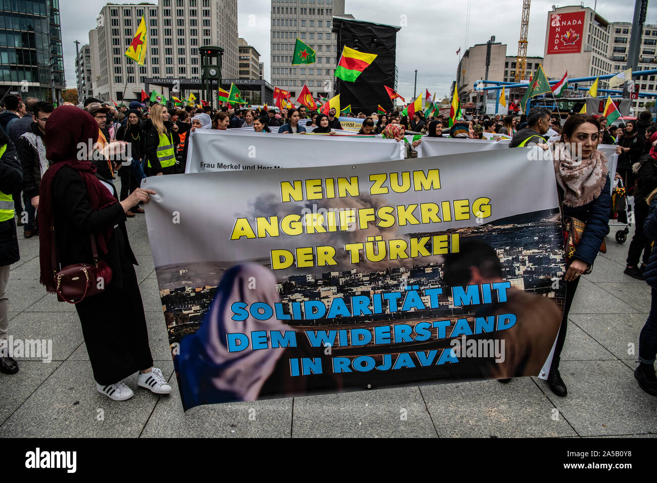 Berlin, Deutschland. Okt, 2019 19. Die Teilnehmer des kurdischen Demonstration gegen die türkische Militäroffensive im Norden Syriens ein Banner am Potsdamer Platz mit der Aufschrift 'Nein zum Krieg der Aggression in der Türkei. Solidarität mit dem Widerstand in Rojava' und für den offiziellen Beginn der Protest warten. Credit: Paul Zinken/dpa/Alamy leben Nachrichten Stockfoto