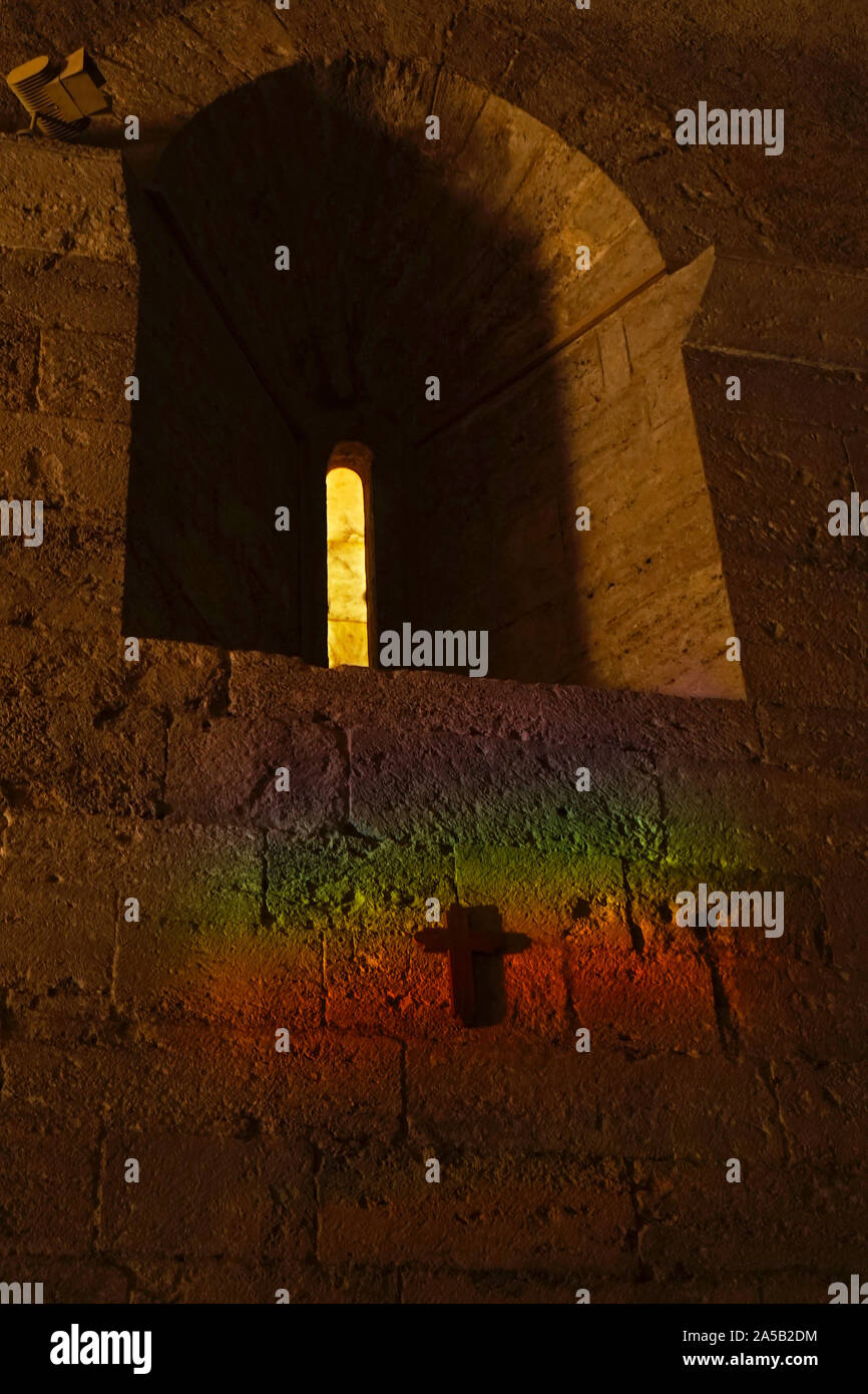 Ein Regenbogen von Licht über eine Kirche mit einem Kreuz kirche Wand reflektiert Stockfoto