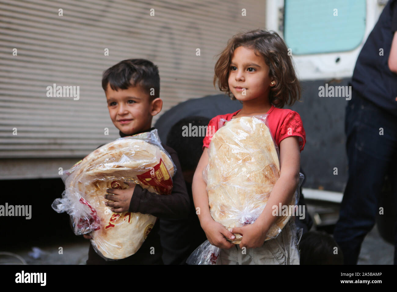 Oktober 18, 2019: Tal Abyad, Syrien. 18. Oktober 2019. Türkische Mitarbeiter humanitärer Hilfsorganisationen Brot für die Zivilbevölkerung verteilen in der syrischen Grenze Stadt Tal Abyad, während die Mitglieder der türkischen Streitkräfte und der syrischen Armee stand Guard der Gegend gegen kurdische Miliz Zellen zu schützen. Der türkischen Armee und den Türkischen Syrischen nationale Armee übernahm die Kontrolle über die syrische Stadt Tal Abyad am Sonntag als Teil der Feder militärische Operation, die von der Türkei gegen die syrische Demokratischen Kräfte (SDF) und der Schutz (YPG). Stockfoto