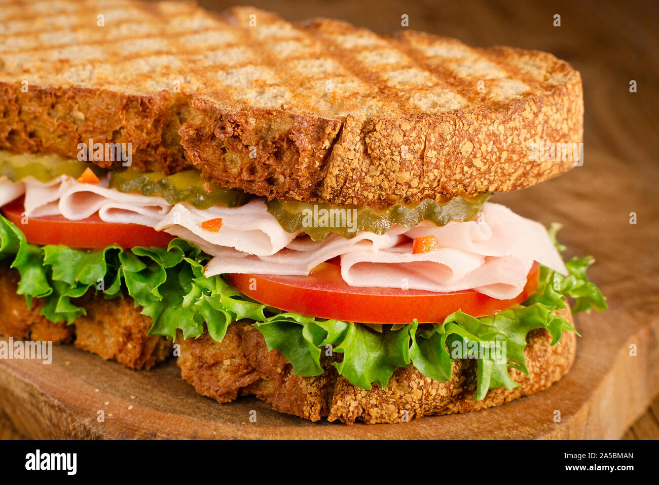 Handgefertigte Türkei Sandwich mit Tomate, Salat und Gurken, auf hölzernen Hintergrund, selektiver Fokus Stockfoto