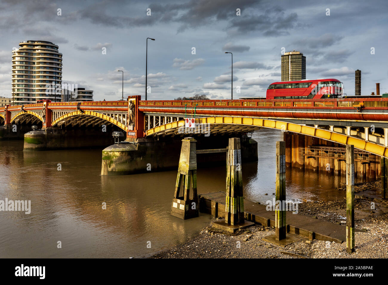 Red London Bus überqueren Sie die Vauxhall Bridge, Riverside Walk, Nine Elms, Pimlico, Westminster, London, England. Großbritannien Stockfoto