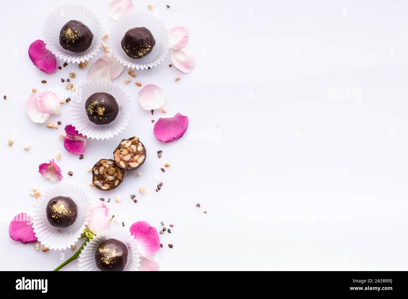 Süße Muster. Ansicht von oben handgefertigte Pralinen mit Nüssen und Honig. Gourmet Schokolade auf einem weißen Hintergrund. Close-up. Soft Focus. Platz kopieren Stockfoto