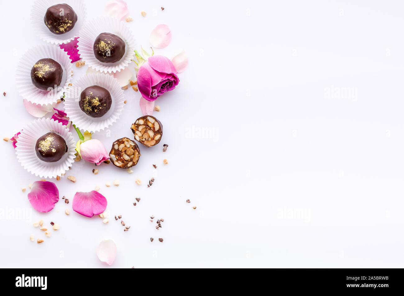 Süße Muster. Ansicht von oben handgefertigte Pralinen mit Nüssen und Honig. Gourmet Schokolade auf einem weißen Hintergrund. Close-up. Soft Focus. Platz kopieren Stockfoto