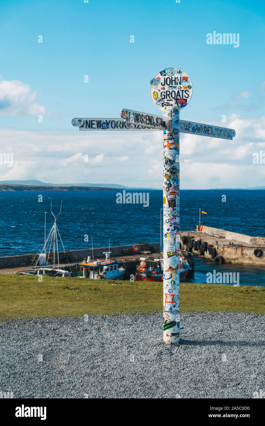 Der berühmte John O' Groats Wegweiser Pole, mit Aufklebern von Touristen verputzt, am äußersten östlichen Punkt der UK Stockfoto