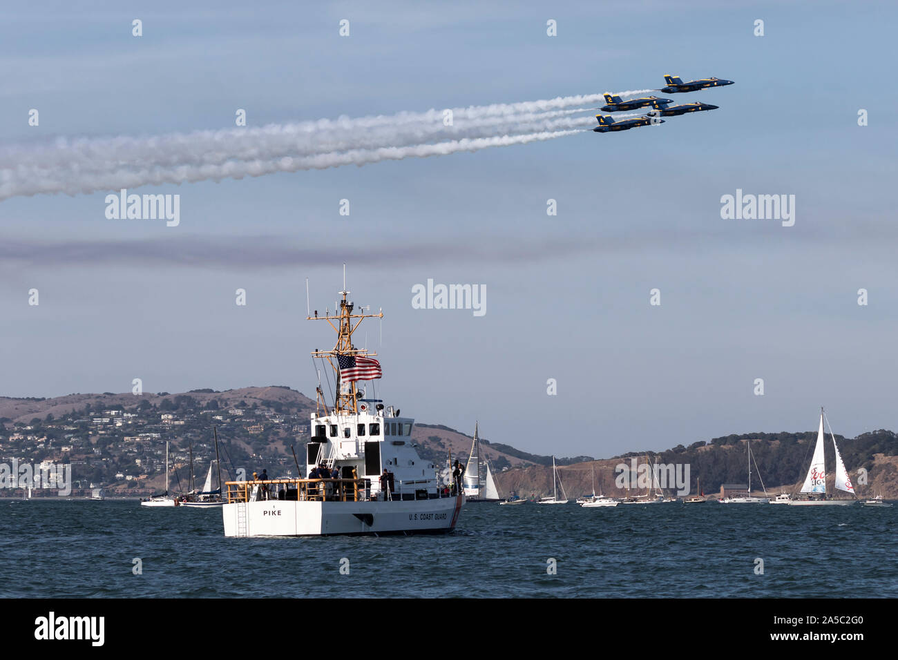 Blue Angels F-18 Hornissen in Diamond formation über das Patrouillenboot Pike (WPB -87365) während einer 2019 San Francisco Fleet Week Flug demonstr Stockfoto