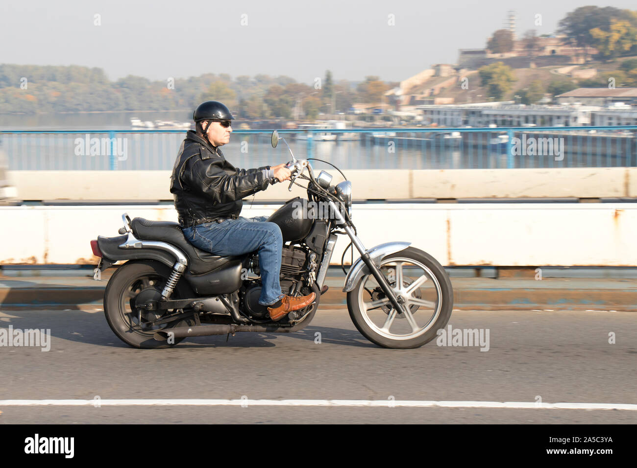 Belgrad, Serbien - 17. Oktober 2019: Ein älterer Mann, Vintage Retro Motorrad über die Stadt Street Bridge Stockfoto