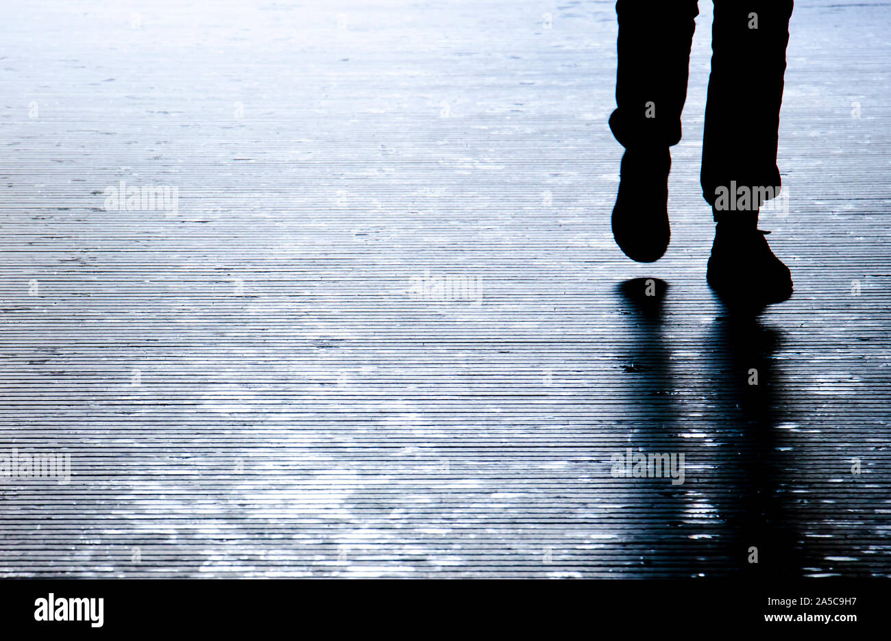 Verschwommene Schatten Silhouette einer Person zu Fuß in der Nacht, Detail der Beine Stockfoto
