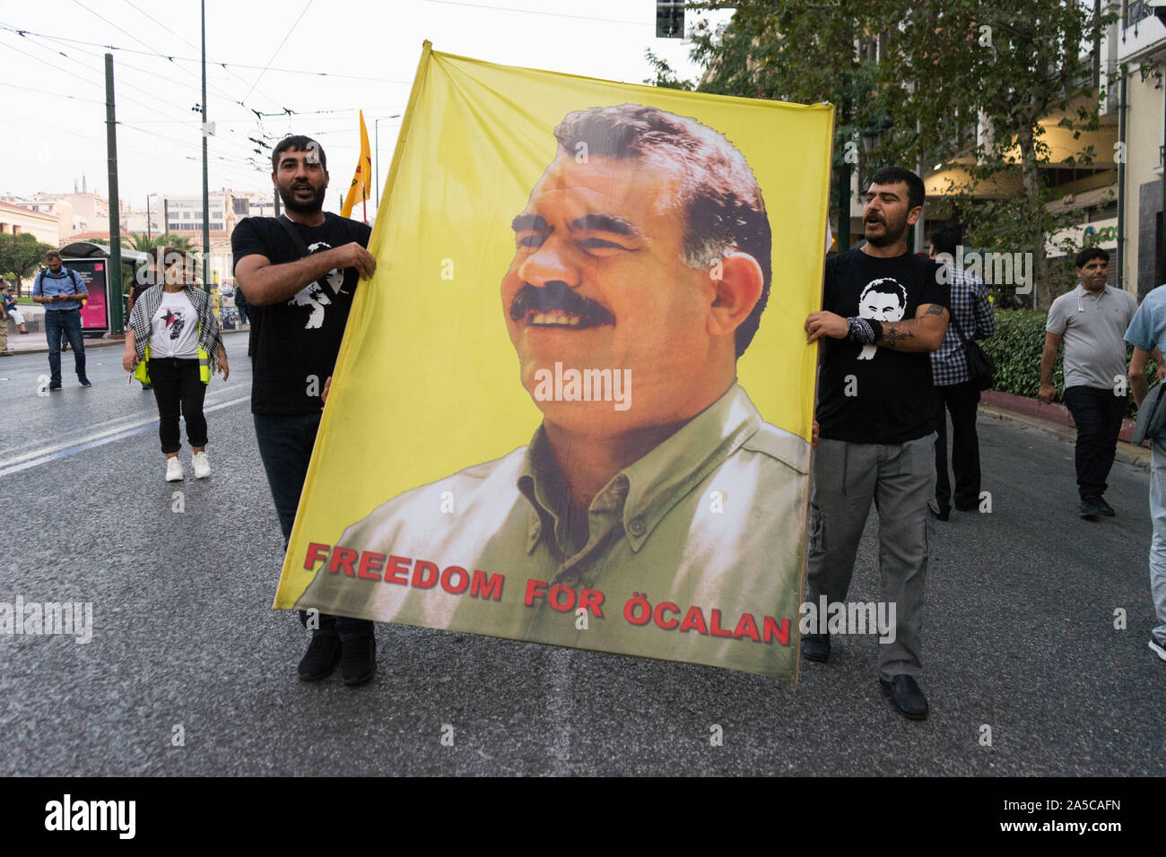 Zwei Kurden Demonstranten halten eine grosse Fahne von Öcalan während der Demonstration. Protest an die Türkische Botschaft, gegen den türkischen militärischen Invasion im Norden und Osten Syrien, Rojava, von Kurden und Solidaritätsgruppen in Athen, Griechenland. Stockfoto