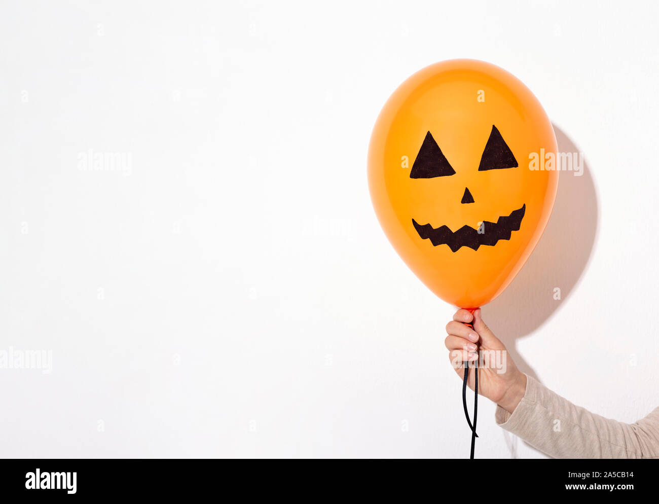 Halloween orange Ballon mit lächelnden Gesicht in der Frau die Hand Stockfoto