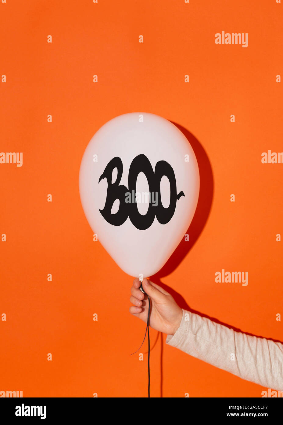 Frau mit Partei buh Ballon über helle orange Stockfoto