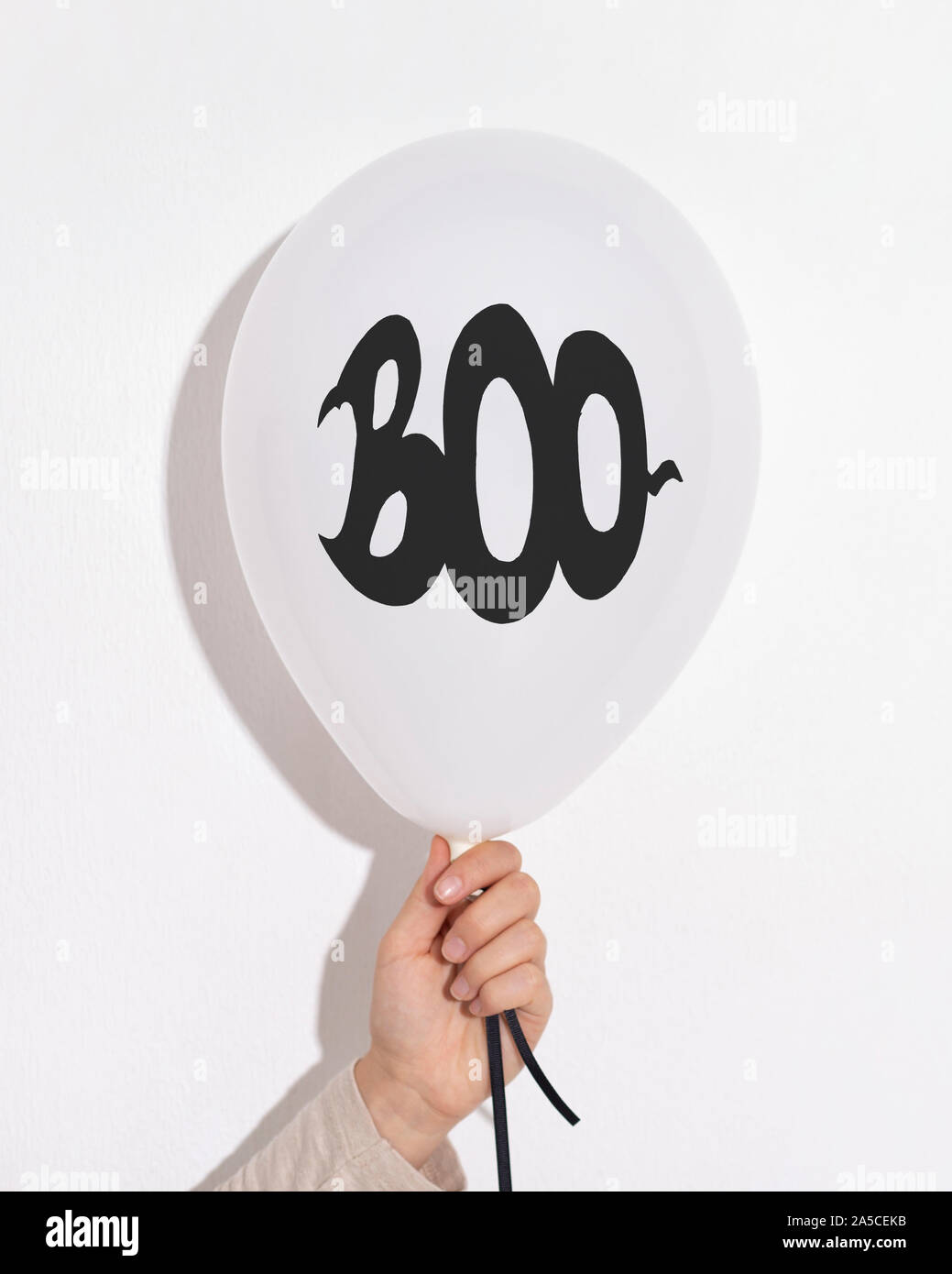 Halloween Ballons mit schwarzem Text in der Hand auf Weiß Stockfoto