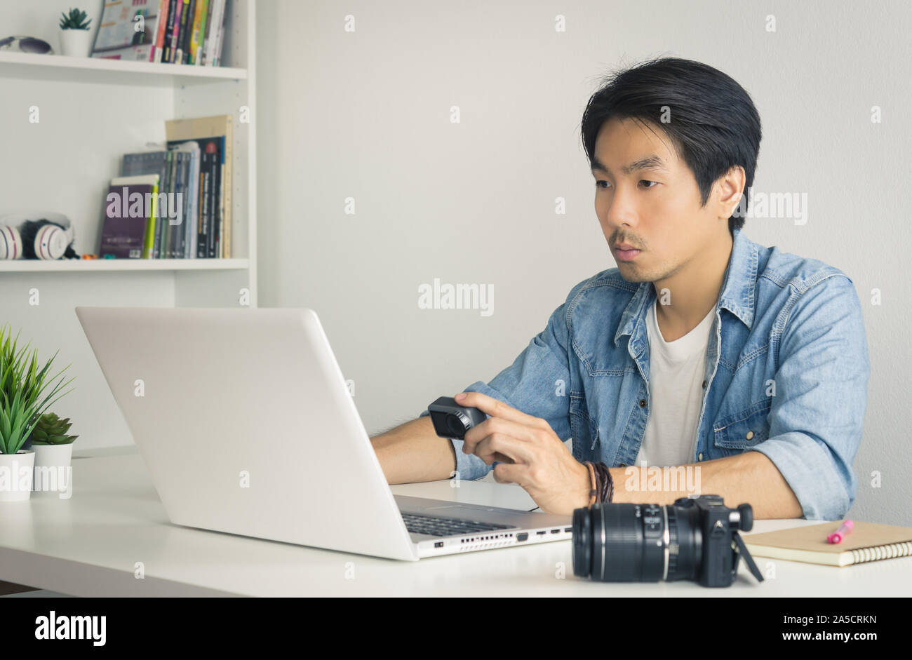 Asiatische Fotograf oder Freiberufler in Denim oder Jeans Shirt Prüfung Mediendatei in Action