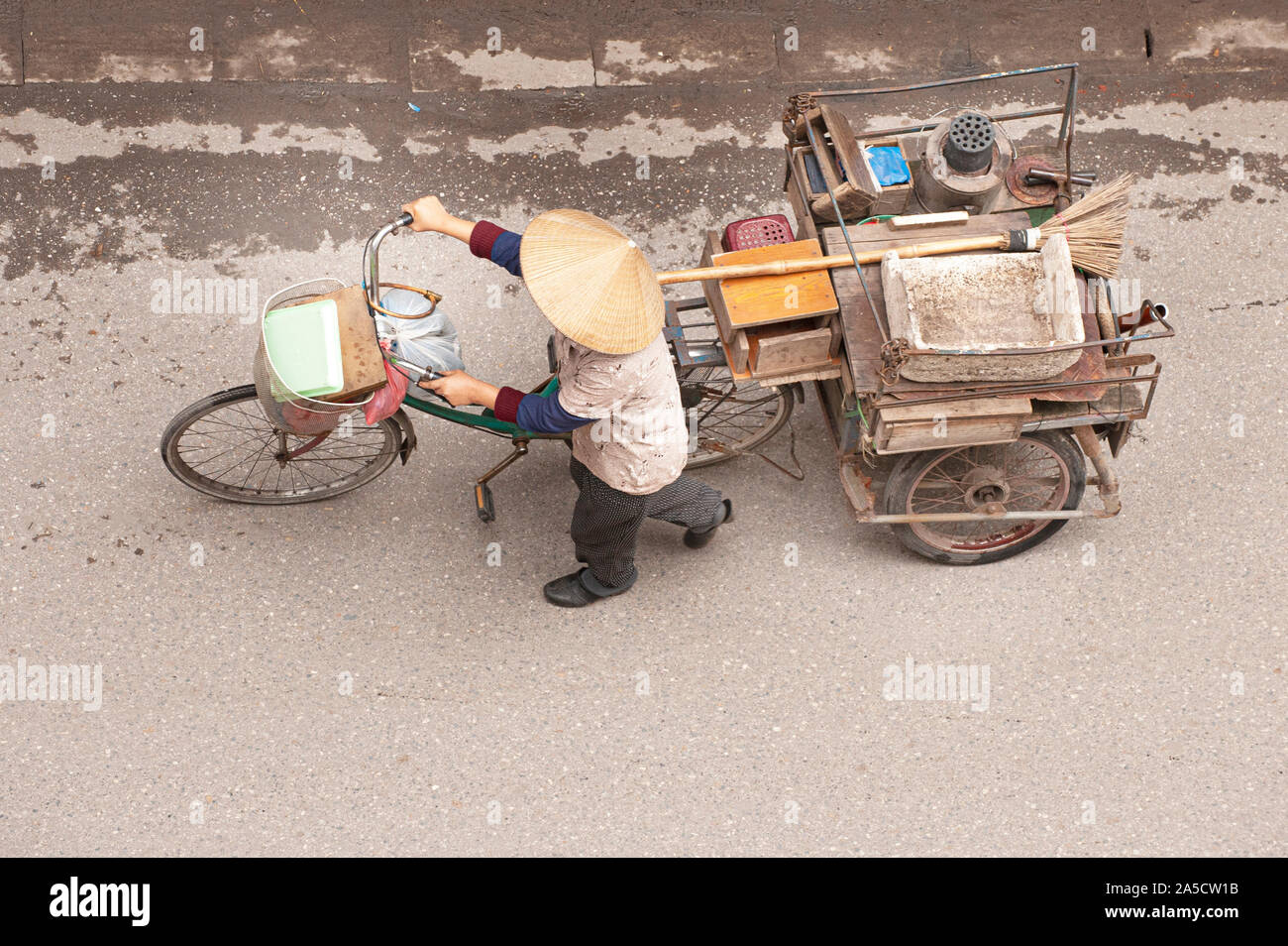 Pedler mit ihren geladenen Dreiräder in Hanoi, Vietnam. Stockfoto