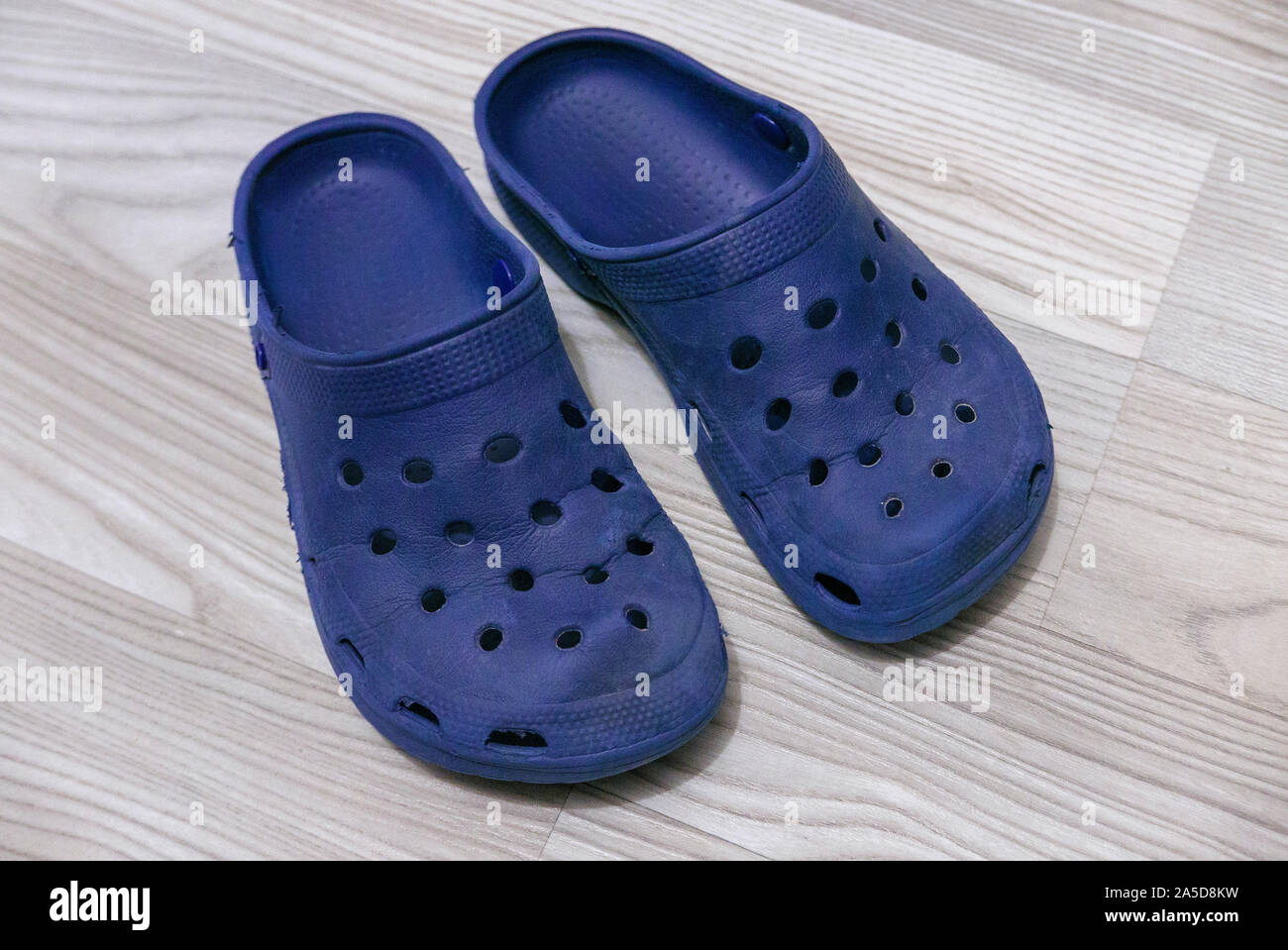 Ansicht von oben ein paar Crocs clogs Schuhe auf der Bodenplatte aus Holz Stockfoto