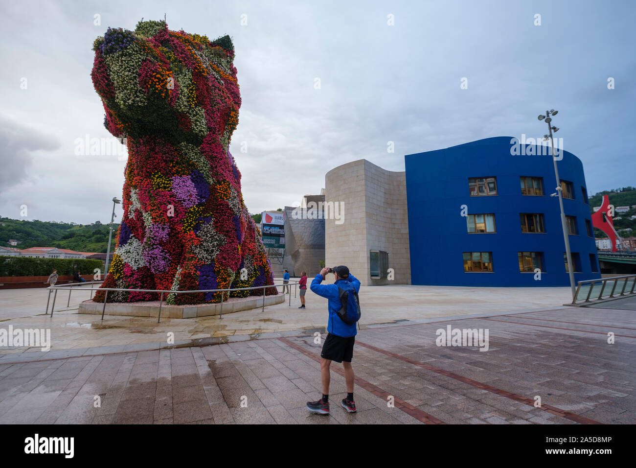 Mann fotografieren der riesigen Blumenbewachsenen hund Skulptur 'Welpen' durch den Künstler Jeff Koons vor dem Guggenheim Museum in Bilbao, Spanien, Europa Stockfoto