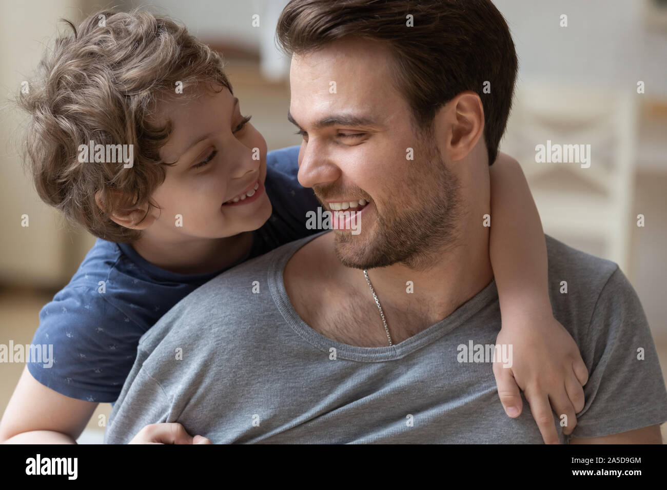 Gerne Vater mit kleinen Sohn auf dem Rücken, umarmen, Spaß Stockfoto