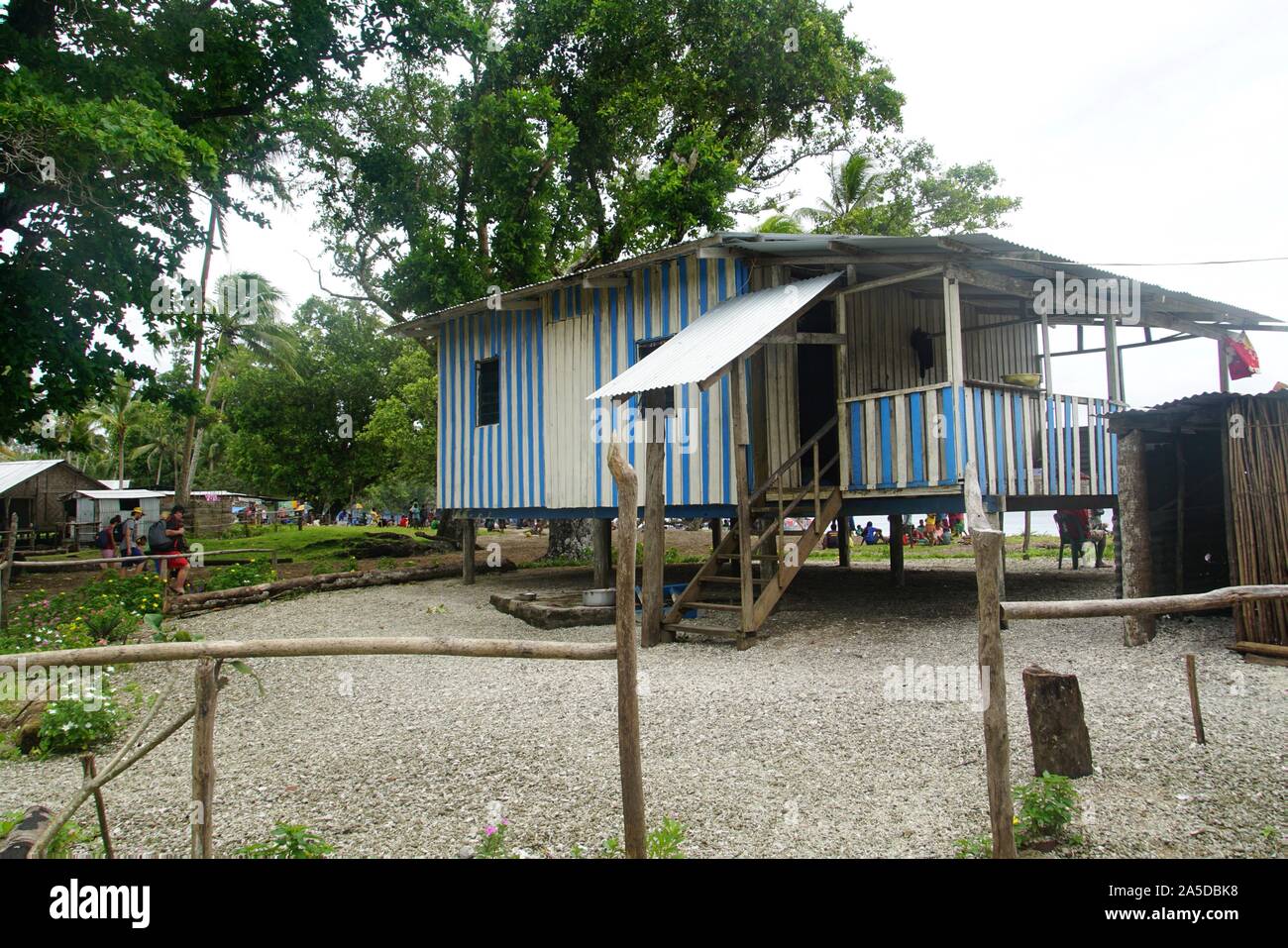 Blau und Weiß Gestreifte Holz Stelzenhaus Aufnahme der Familie eines Lehrers auf der Insel Kiriwina Stockfoto